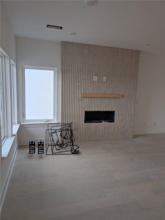 living room featuring wood finished floors, a fireplace, and baseboards