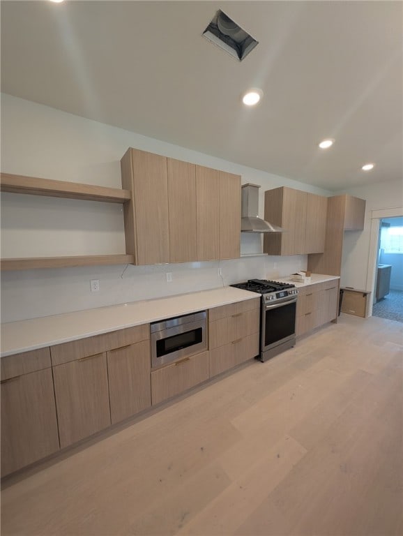 kitchen featuring gas stove, wall chimney exhaust hood, open shelves, modern cabinets, and light brown cabinets