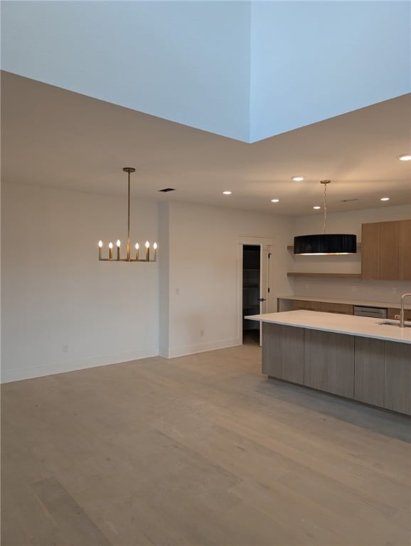 kitchen with a sink, modern cabinets, light countertops, recessed lighting, and light wood-type flooring