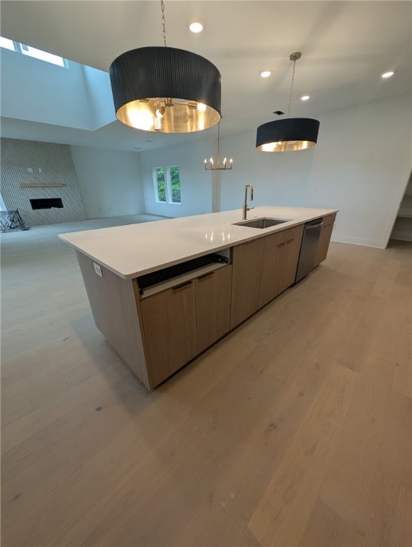 kitchen featuring a sink, stainless steel dishwasher, light wood-type flooring, a center island with sink, and recessed lighting