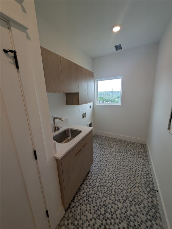 kitchen featuring a sink, light countertops, baseboards, light flooring, and recessed lighting