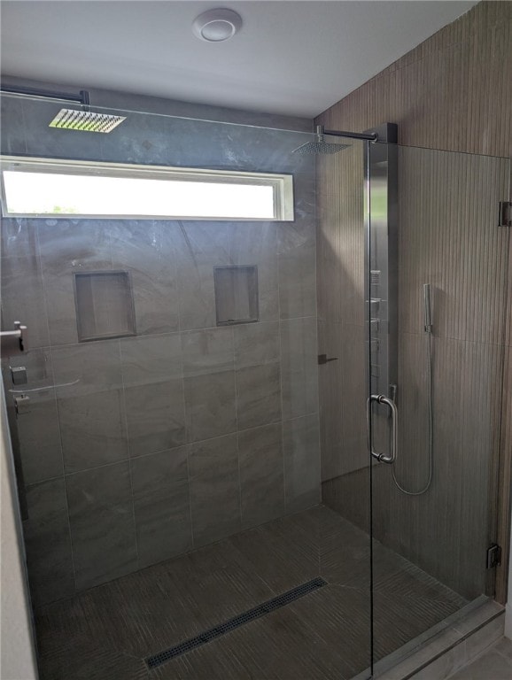bathroom with a shower stall and tile patterned floors