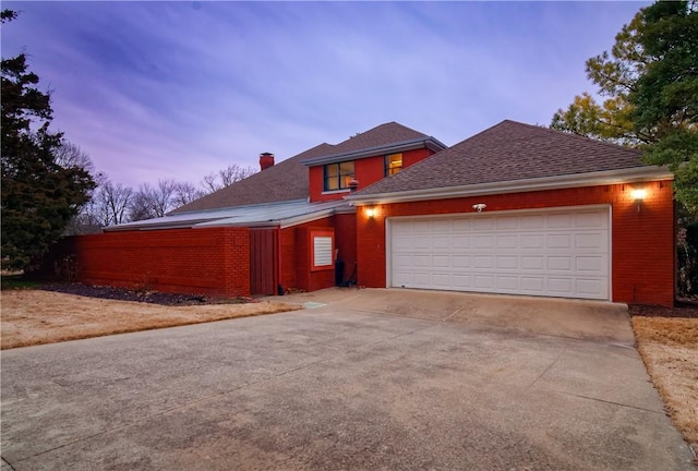 2356 N Primrose Ln, Fayetteville, AR 72703 - view of front of home featuring a chimney, concrete driveway, brick siding, and a garage