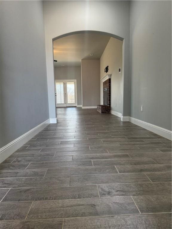2401 Armstrong Ln, Pea Ridge, AR 72751 - unfurnished living room featuring baseboards, arched walkways, and wood finish floors
