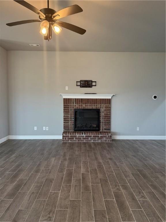 2401 Armstrong Ln, Pea Ridge, AR 72751 - unfurnished living room featuring visible vents, a ceiling fan, baseboards, a brick fireplace, and dark wood-style flooring