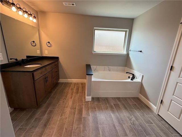 2401 Armstrong Ln, Pea Ridge, AR 72751 - bathroom featuring vanity, a bath, visible vents, and wood finish floors
