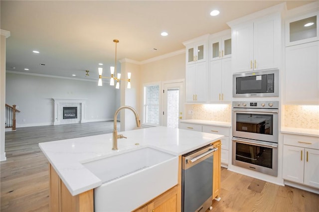 5914 SW Bloomsbury Rd, Bentonville, AR 72713 - kitchen featuring appliances with stainless steel finishes, a sink, crown molding, light wood-type flooring, and backsplash