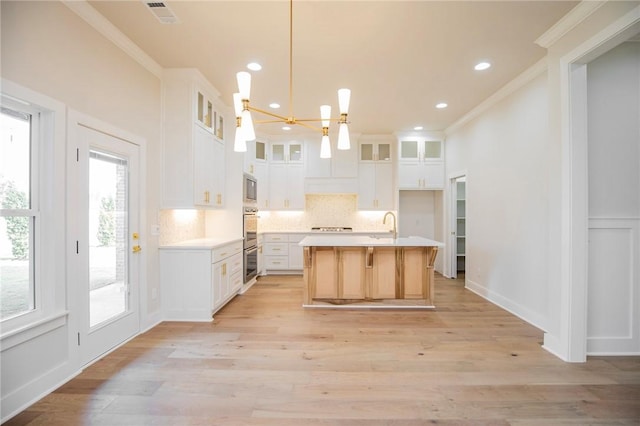 5914 SW Bloomsbury Rd, Bentonville, AR 72713 - kitchen featuring crown molding, backsplash, appliances with stainless steel finishes, light countertops, and light wood-style floors