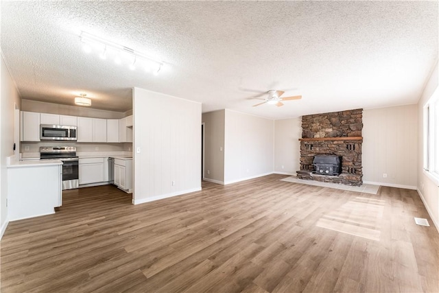 12 Ipswich Dr, Bella Vista, AR 72714 - unfurnished living room featuring a textured ceiling, a ceiling fan, wood finished floors, and track lighting