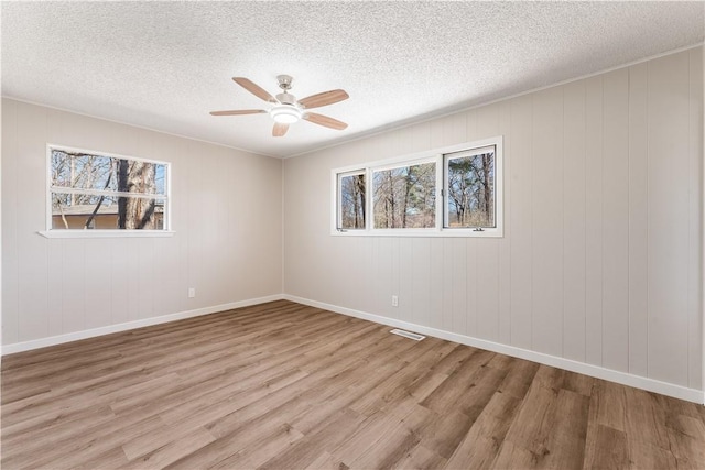12 Ipswich Dr, Bella Vista, AR 72714 - empty room with plenty of natural light, a ceiling fan, light wood-style flooring, and a textured ceiling
