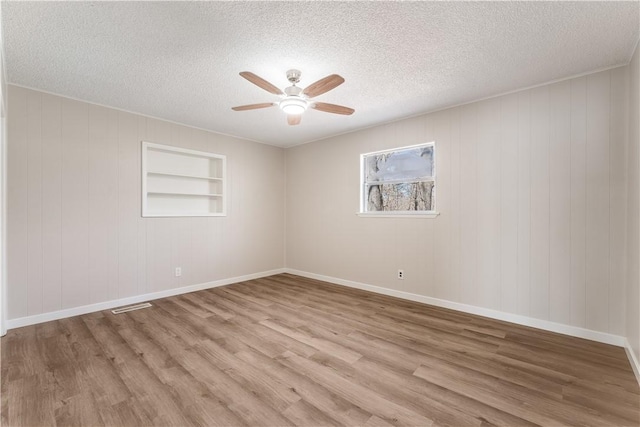 12 Ipswich Dr, Bella Vista, AR 72714 - spare room featuring a ceiling fan, light wood-style flooring, and a textured ceiling