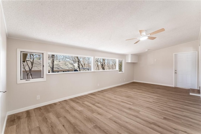 12 Ipswich Dr, Bella Vista, AR 72714 - spare room with a textured ceiling, ceiling fan, light wood-type flooring, and vaulted ceiling