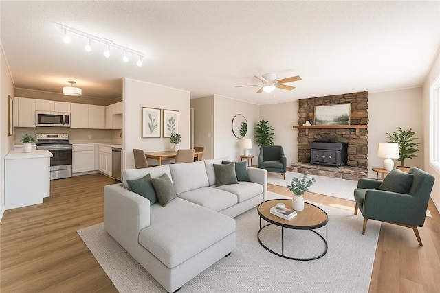 12 Ipswich Dr, Bella Vista, AR 72714 - living room with light wood-style flooring, a ceiling fan, and a wood stove