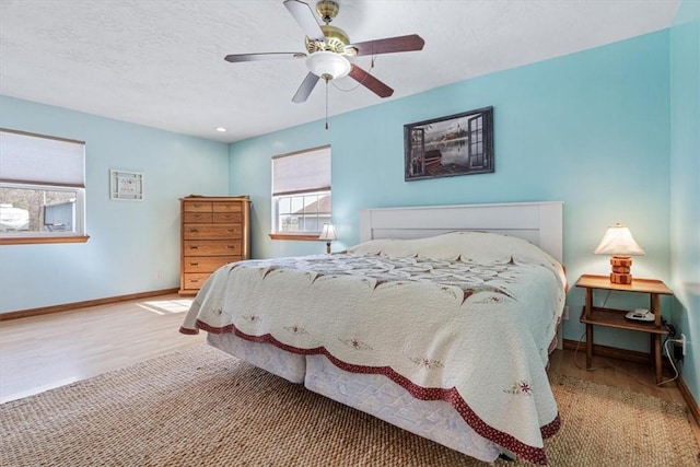 14745 Russell Rd, Siloam Springs, AR 72761 - bedroom with a textured ceiling, baseboards, a ceiling fan, and wood finished floors