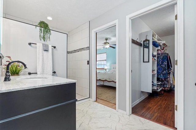 14745 Russell Rd, Siloam Springs, AR 72761 - ensuite bathroom featuring a spacious closet, ceiling fan, a shower stall, vanity, and marble finish floor