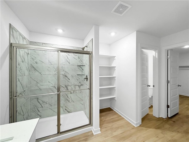 575 W Canada Dr, Farmington, AR 72730 - bathroom featuring a walk in closet, recessed lighting, a shower stall, wood finished floors, and visible vents