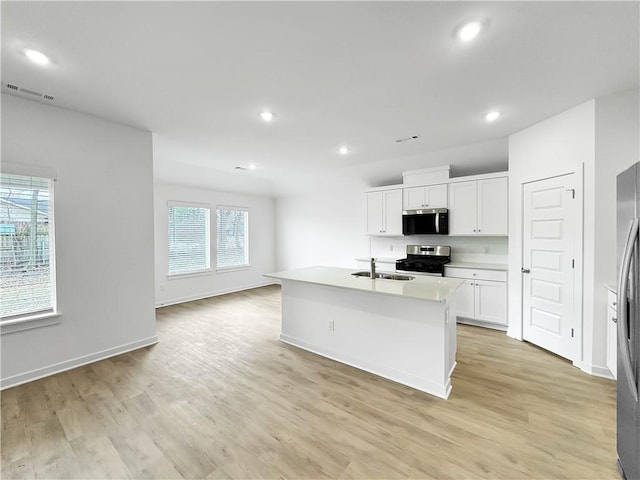575 W Canada Dr, Farmington, AR 72730 - kitchen with a sink, light wood-style flooring, stainless steel appliances, recessed lighting, and white cabinetry
