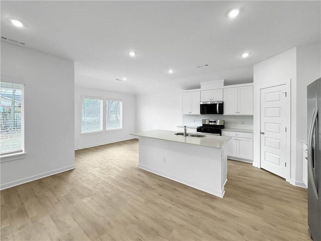 575 W Canada Dr, Farmington, AR 72730 - kitchen with visible vents, light wood-style floors, white cabinetry, a sink, and stainless steel appliances