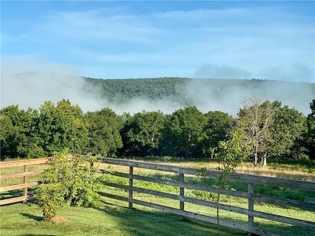 exterior space with a rural view, a forest view, and fence