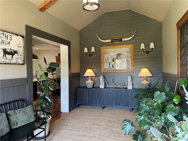 interior space featuring wooden walls, wainscoting, and vaulted ceiling