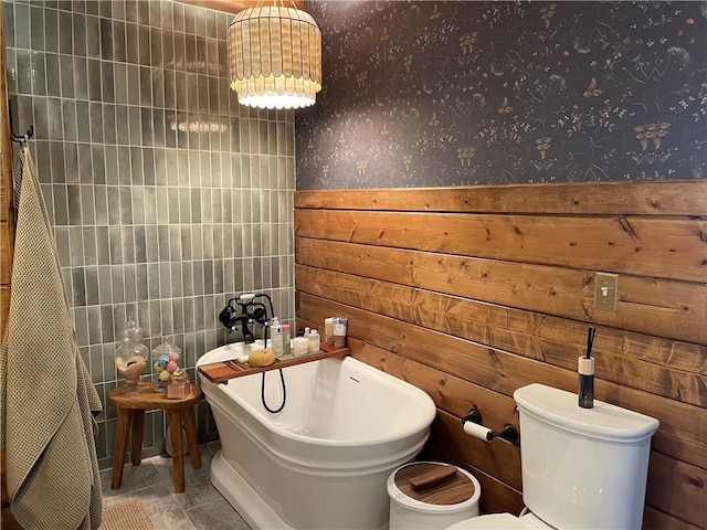 full bathroom featuring a freestanding tub, wallpapered walls, and toilet