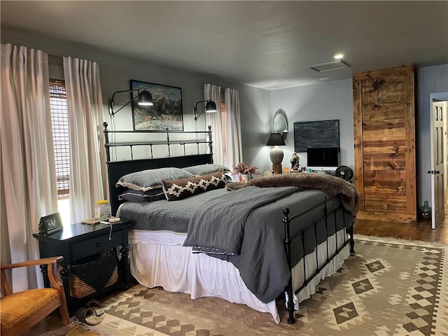 bedroom featuring wood finished floors and visible vents