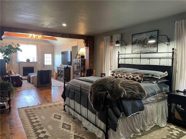 bedroom with a fireplace and wood finished floors