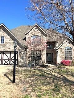 3899 Pasofino Loop, Springdale, AR 72764 - view of front of house with concrete driveway, a garage, and stone siding