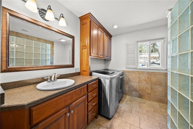 21621 Vista Shores Dr, Garfield, AR 72732 - washroom with a sink, tile walls, cabinet space, and washing machine and clothes dryer