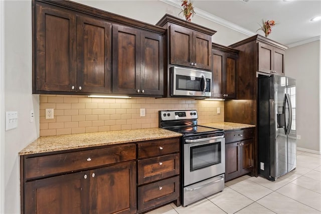 kitchen with dark brown cabinetry, crown molding, light tile patterned floors, light stone countertops, and appliances with stainless steel finishes