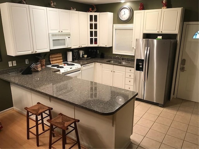 258B Vista, Mount Ida, AR 71957 - kitchen with white appliances, dark stone countertops, a peninsula, a sink, and white cabinetry