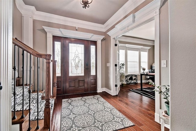 entryway with crown molding, stairway, and wood finished floors