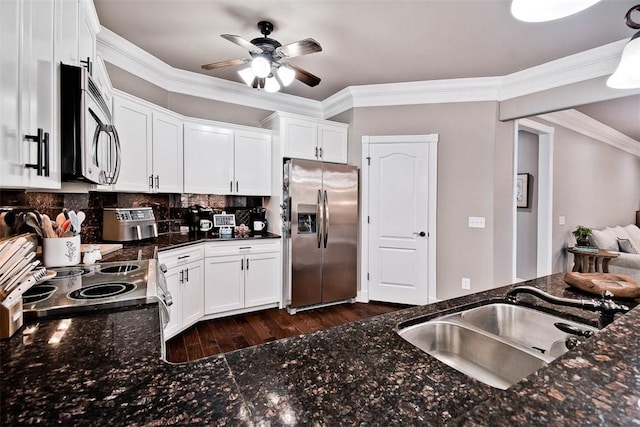 kitchen featuring white cabinetry, ornamental molding, a sink, ceiling fan, and appliances with stainless steel finishes