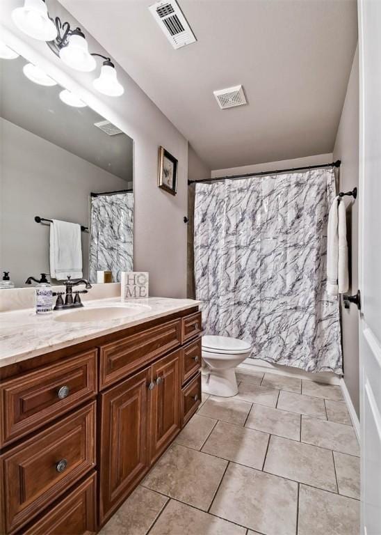 bathroom with toilet, vanity, tile patterned flooring, and visible vents
