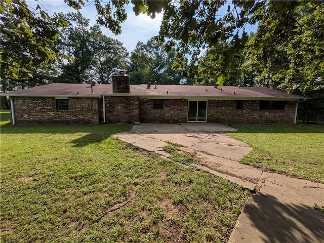 116 Stegall Rd, Clarksville, AR 72830 - back of house featuring a patio, a chimney, brick siding, and a yard