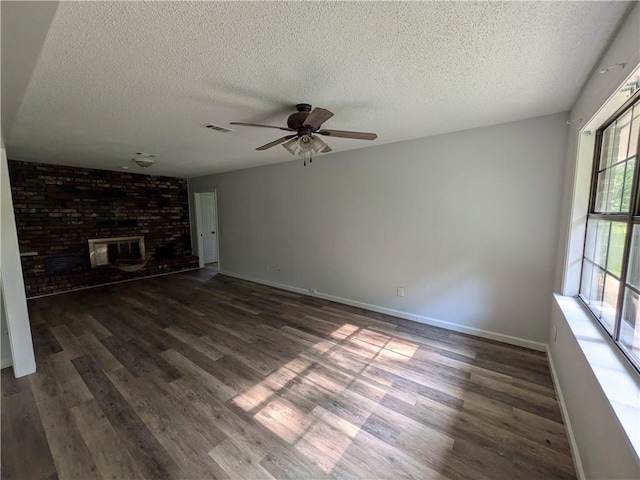 116 Stegall Rd, Clarksville, AR 72830 - unfurnished living room with a textured ceiling, dark wood-style floors, ceiling fan, and a fireplace