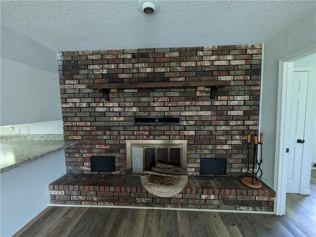 116 Stegall Rd, Clarksville, AR 72830 - detailed view of a brick fireplace, a textured ceiling, and wood finished floors