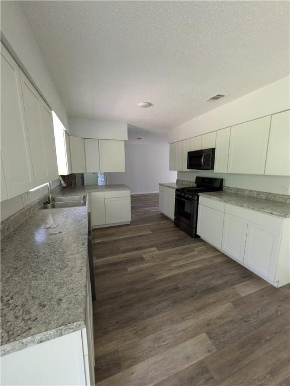 116 Stegall Rd, Clarksville, AR 72830 - kitchen featuring black appliances, white cabinets, a textured ceiling, and dark wood-style flooring