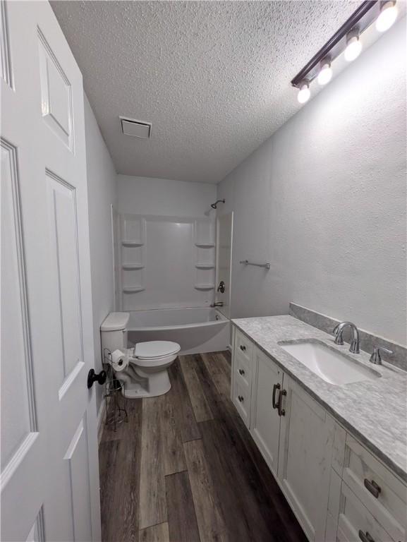 116 Stegall Rd, Clarksville, AR 72830 - bathroom featuring a textured ceiling, wood finished floors, vanity, and  shower combination