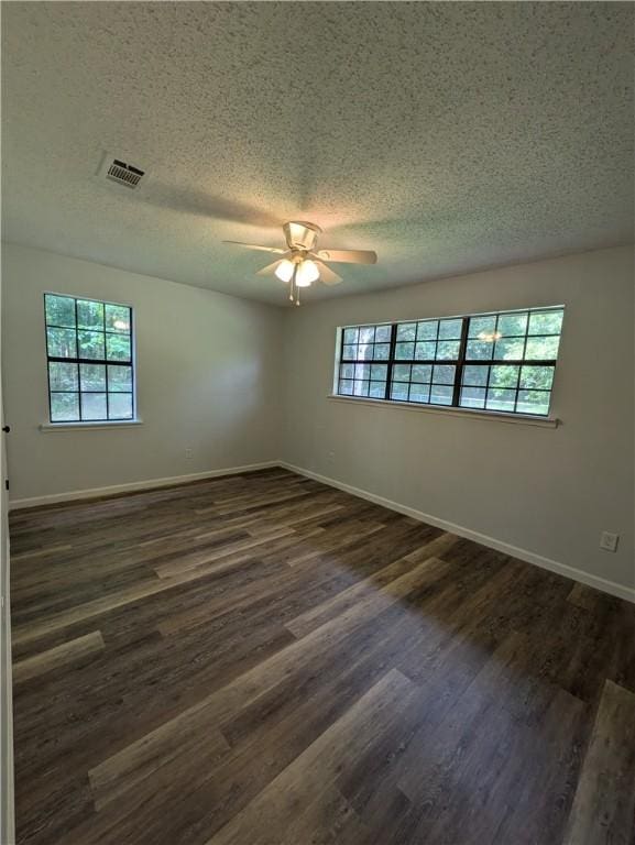 116 Stegall Rd, Clarksville, AR 72830 - empty room with healthy amount of natural light, ceiling fan, a textured ceiling, and dark wood-style flooring