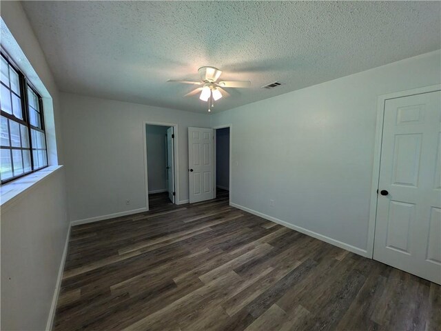116 Stegall Rd, Clarksville, AR 72830 - unfurnished bedroom featuring dark wood-style floors, a textured ceiling, and ceiling fan