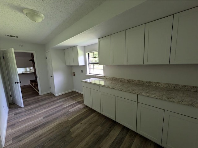 116 Stegall Rd, Clarksville, AR 72830 - kitchen featuring a textured ceiling, dark wood-type flooring, white cabinetry, and light stone countertops
