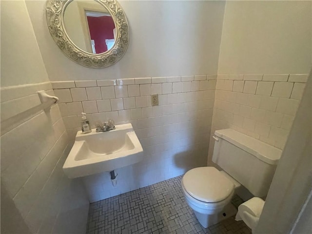 803 W Main St, Clarksville, AR 72830 - half bathroom with toilet, tile walls, a sink, and a wainscoted wall