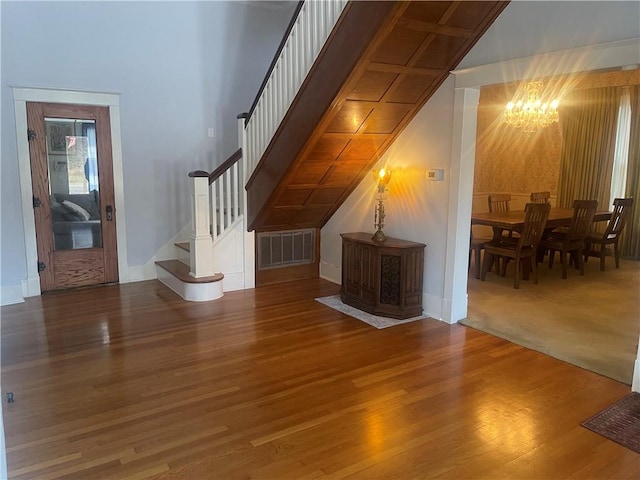 803 W Main St, Clarksville, AR 72830 - unfurnished living room with a chandelier, stairs, wood finished floors, and baseboards