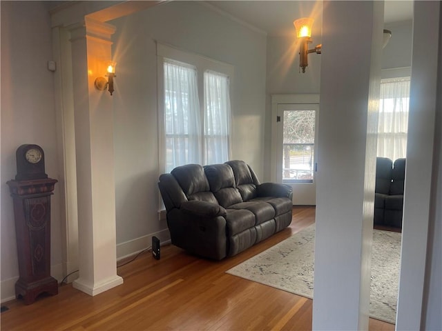 803 W Main St, Clarksville, AR 72830 - living room with wood finished floors, baseboards, ornamental molding, and ornate columns