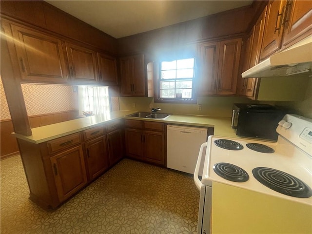 803 W Main St, Clarksville, AR 72830 - kitchen with white appliances, under cabinet range hood, light countertops, a sink, and brown cabinets