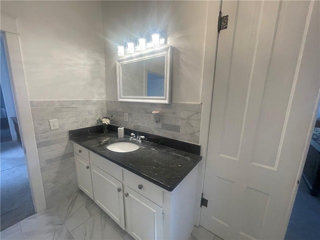 803 W Main St, Clarksville, AR 72830 - bathroom with vanity, marble finish flooring, tile walls, and a wainscoted wall