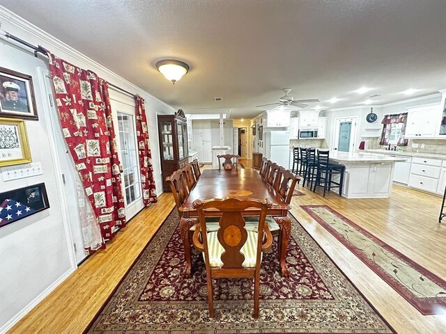 5121 E State Highway 22, Paris, AR 72855 - dining room with light wood-style floors, crown molding, ceiling fan, and a textured ceiling
