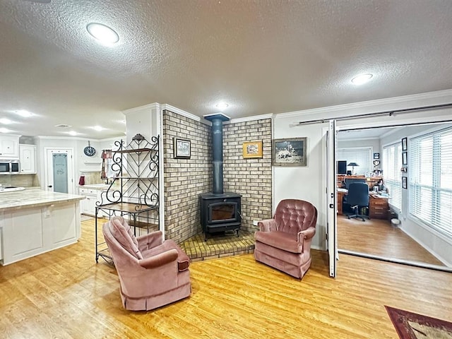 5121 E State Highway 22, Paris, AR 72855 - living area featuring light wood-style floors, ornamental molding, a textured ceiling, a wood stove, and a desk