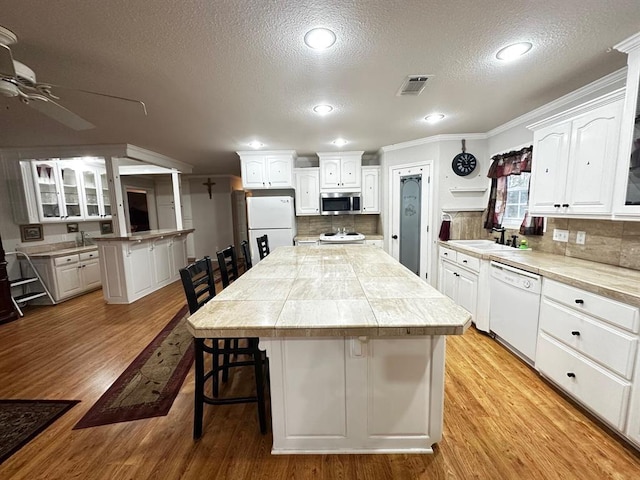 5121 E State Highway 22, Paris, AR 72855 - kitchen featuring white appliances, a kitchen island, a textured ceiling, a ceiling fan, and white cabinets